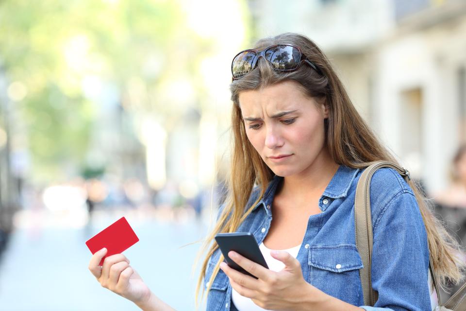 Worried woman having trouble with online payment on her phone.